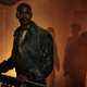 Raych Seldon (Alfred Enoch) looks concerned while standing at railing in Foundation.